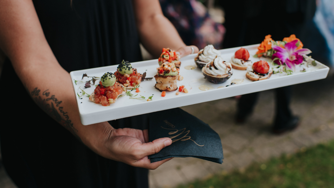 Guests seated at long banquet tables during a wedding reception at a venue in Toronto, catered by elle cuisine.